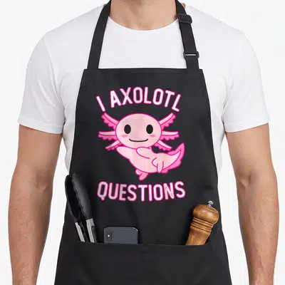 Axolotl question kawaii apron - Pink cartoon axolotl with arched I Axolotl Questions text — shown on a black cotton canvas apron against a white background