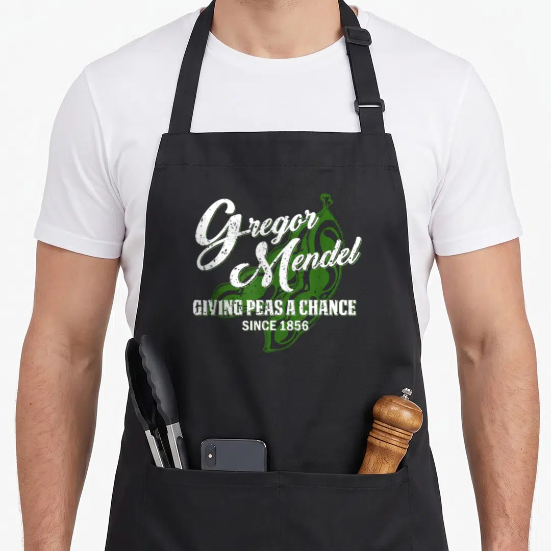 Mendel biology apron - Green pea pod with distressed white text reading Gregor Mendel giving peas a chance since 1856 — shown on a black cotton canvas apron against a white background
