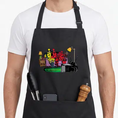 Couch gag aprons - Cartoon Deadpool and Wolverine sitting on purple couch with TV and lamp in living room scene — shown on a black cotton canvas apron against a white background