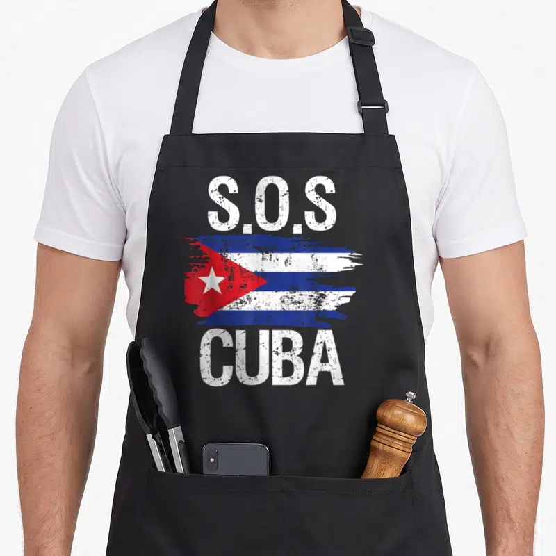 Sos cuban boy apron - Distressed S.O.S CUBA text above and below a painted Cuban flag in blue, white, and red — shown on a black cotton canvas apron against a white background