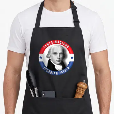 Founder patriotic apron - James Madison Founding Father portrait in red white blue circle with stars — shown on a black cotton canvas apron against a white background