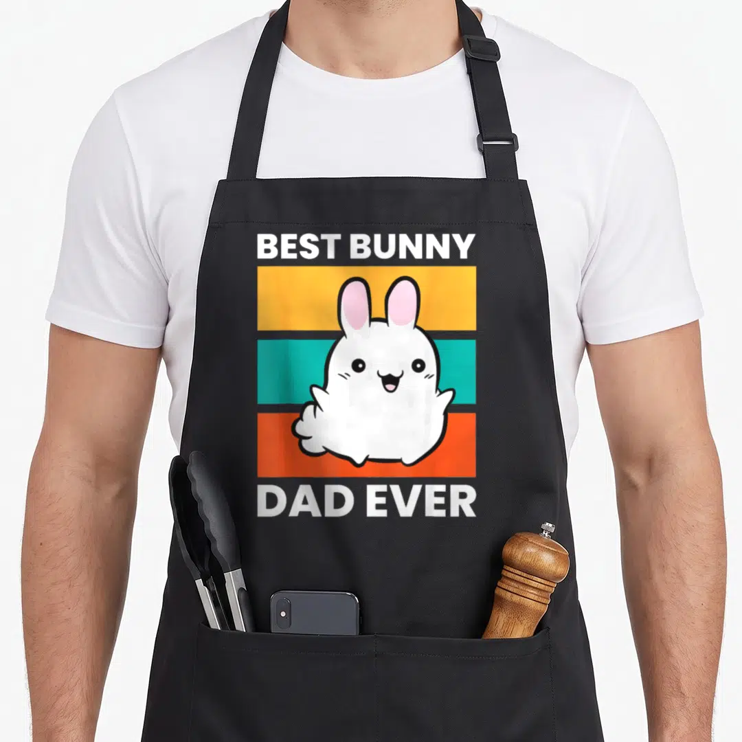 Papa bunny apron - Cartoon white rabbit on yellow teal orange stripes with text BEST BUNNY DAD EVER — shown on a black cotton canvas apron against a white background