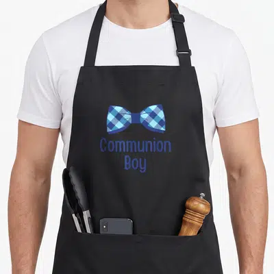 Holy christian communion aprons - Blue plaid bow tie above stacked Communion Boy text in blue font — shown on a black cotton canvas apron against a white background