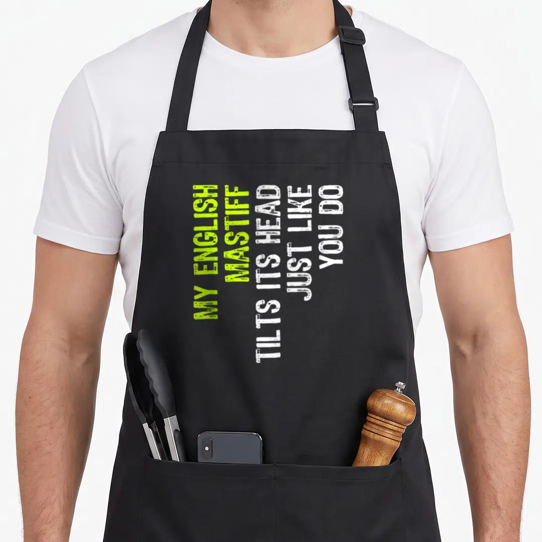 Mastiff tilt dog apron - Vertical lime green and white text reading My English Mastiff Tilts Its Head Just Like You Do — shown on a black cotton canvas apron against a white background