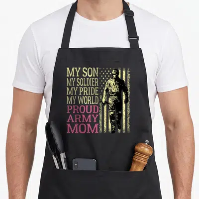 Soldier mother son aprons - Stacked text My Son My Soldier My Pride My World Proud Army Mom beside a standing soldier — shown on a black cotton canvas apron against a white background