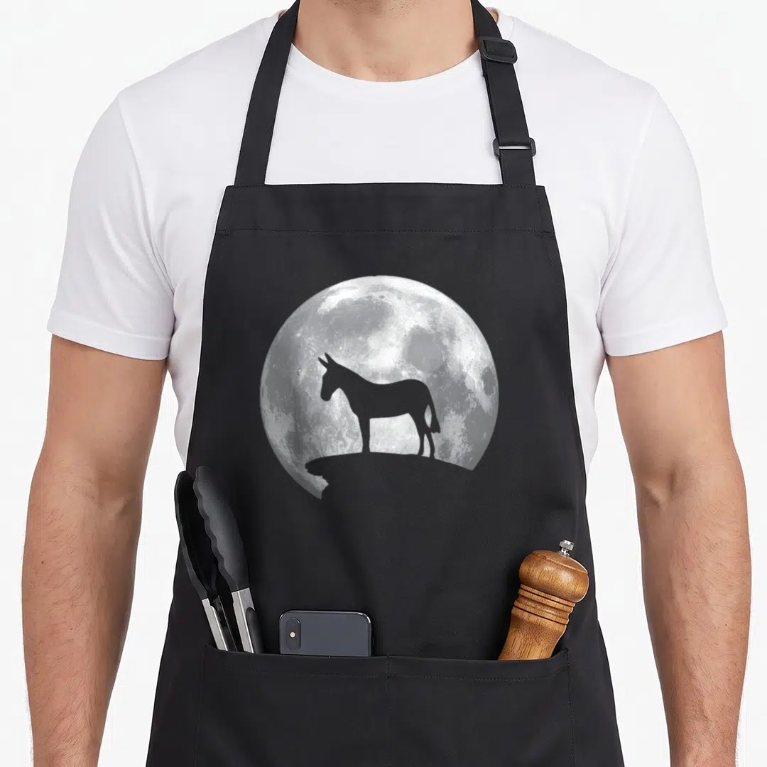 Animal mule apron - Grey donkey silhouette standing in front of a white full moon photo print — shown on a black cotton canvas apron against a white background