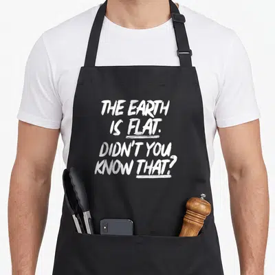 Didnt earth apron - White brush-stroke text reading THE EARTH IS FLAT with underlines beneath second and fourth lines — shown on a black cotton canvas apron against a white background