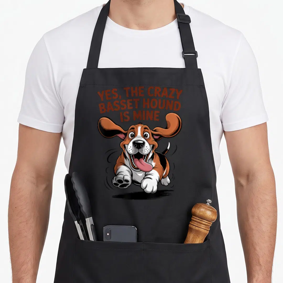 Cartoon cooking with dog apron - Running cartoon Basset Hound with YES THE CRAZY BASSET HOUND IS MINE text — shown on a black cotton canvas apron against a white background