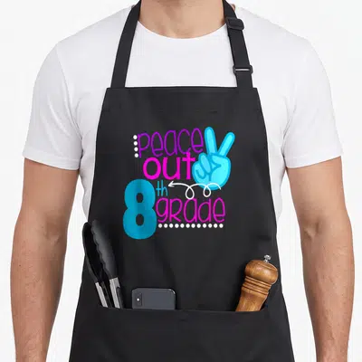 School moving day apron - peace out 8th grade text with blue peace sign hand and white dots on black background — shown on a black cotton canvas apron against a white background