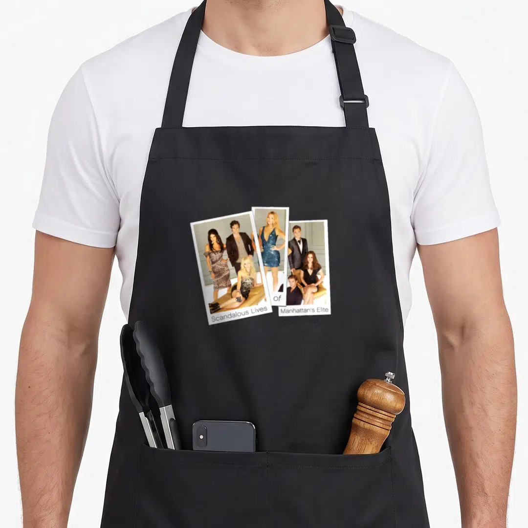 Cute gossip apron - Three polaroid photos of people with text Scandalous Lives Of Manhattan's Elite on white borders — shown on a black cotton canvas apron against a white background