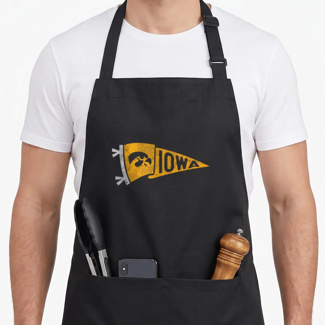 Pennant iowa hawkeyes apron - Distressed yellow pennant with IOWA text and hawk head on black apron — shown on a black cotton canvas apron against a white background