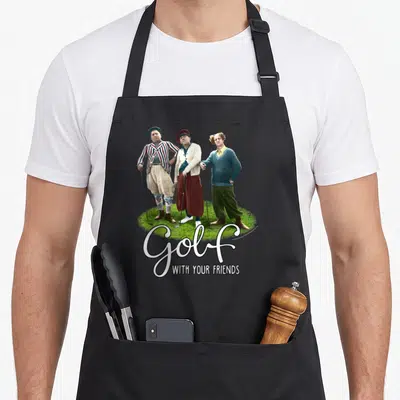 Tts golf apron - Three men on grass with Golf WITH YOUR FRIENDS text — shown on a black cotton canvas apron against a white background