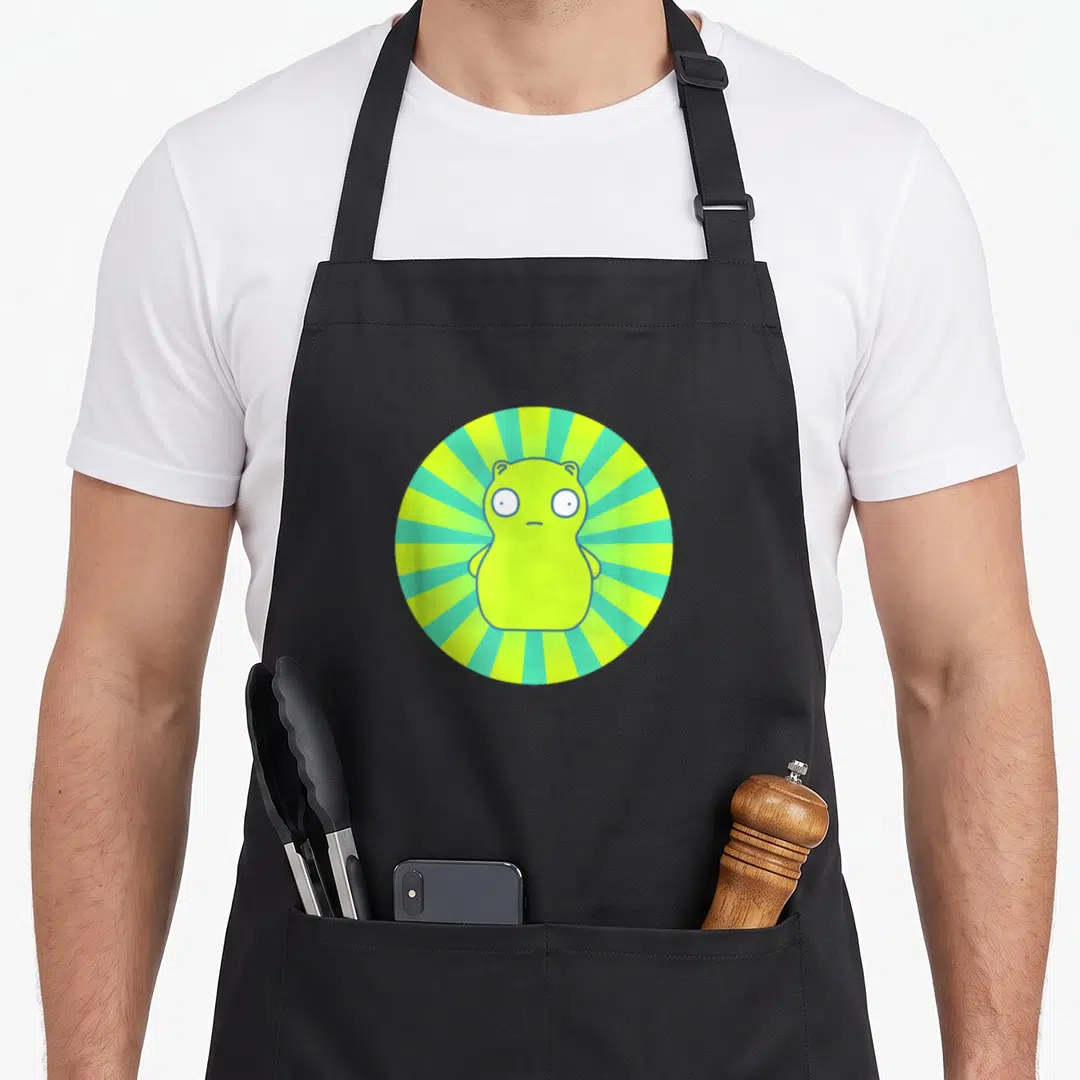 Kopi bobs burger apron - Lime green monster centered in a teal and lime green circular sunburst pattern — shown on a black cotton canvas apron against a white background