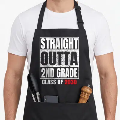 Outta 2nd apron - Stacked distressed text reading Straight Outta 2nd Grade Class of 2030 in white grey and red — shown on a black cotton canvas apron against a white background