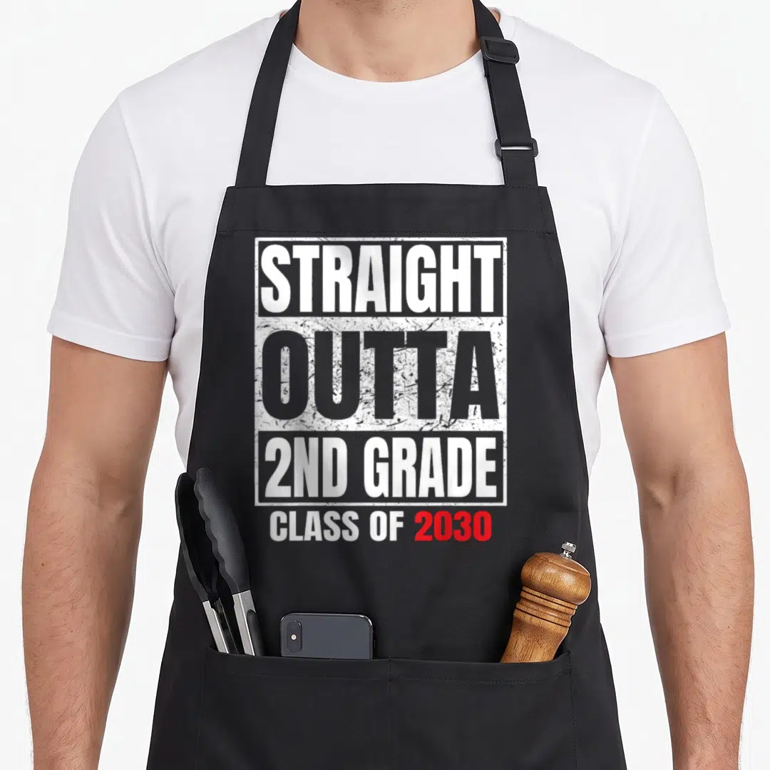 Outta 2nd apron - Stacked distressed text reading Straight Outta 2nd Grade Class of 2030 in white grey and red — shown on a black cotton canvas apron against a white background