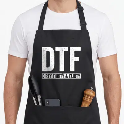 Flirty funny dirty aprons - Distressed white DTF text above black banner reading DIRTY THIRTY & FLIRTY — shown on a black cotton canvas apron against a white background