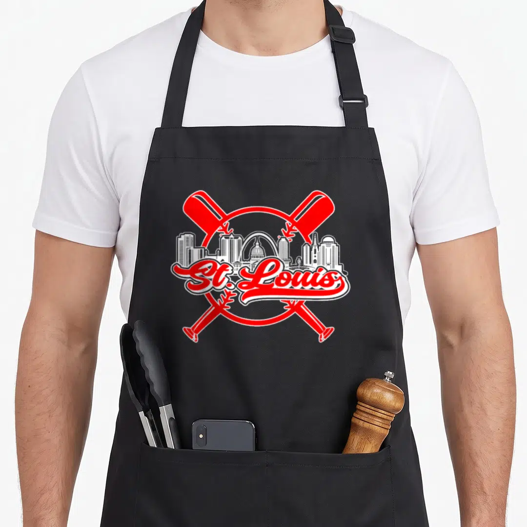 Funny louis baseball apron - Red crossed bats over white St. Louis skyline with red script text inside circular border — shown on a black cotton canvas apron against a white background