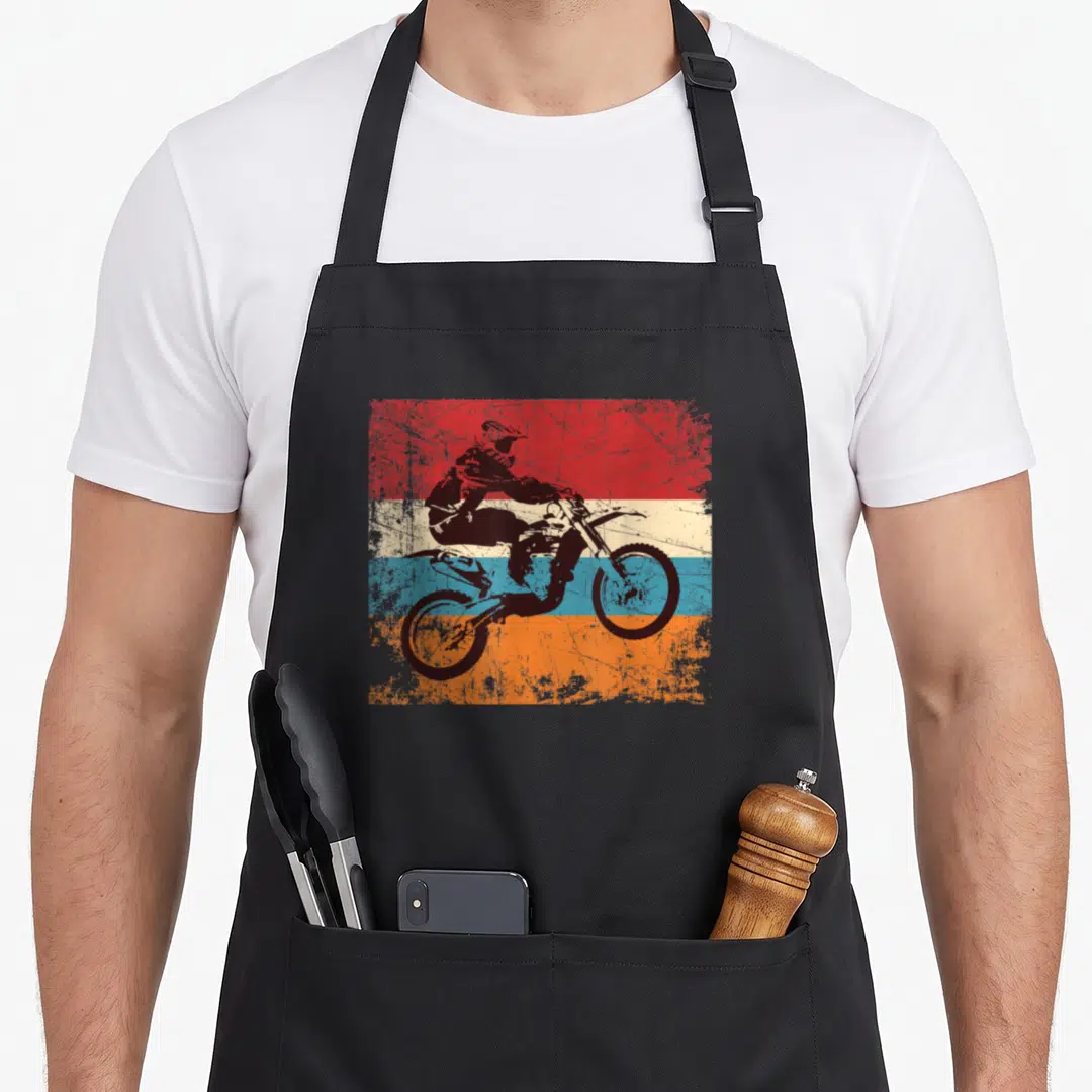 Motorcycle road apron - Black motocross rider silhouette over red orange blue and cream horizontal stripes — shown on a black cotton canvas apron against a white background
