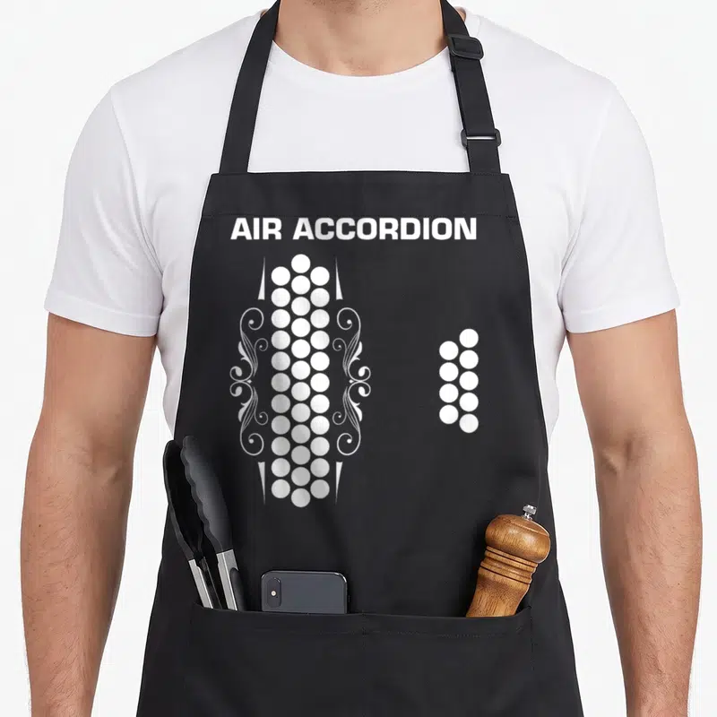 Music mexican apron - White accordion buttons and AIR ACCORDION text with decorative swirls on grey background — shown on a black cotton canvas apron against a white background