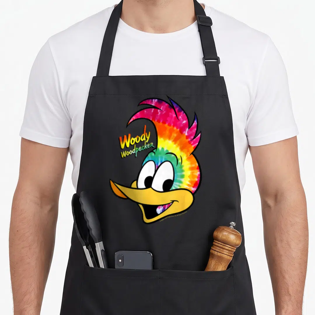 Funny portrait tie-dye apron - Cartoon woodpecker head in yellow red blue and green tie-dye with name to left of crest — shown on a black cotton canvas apron against a white background