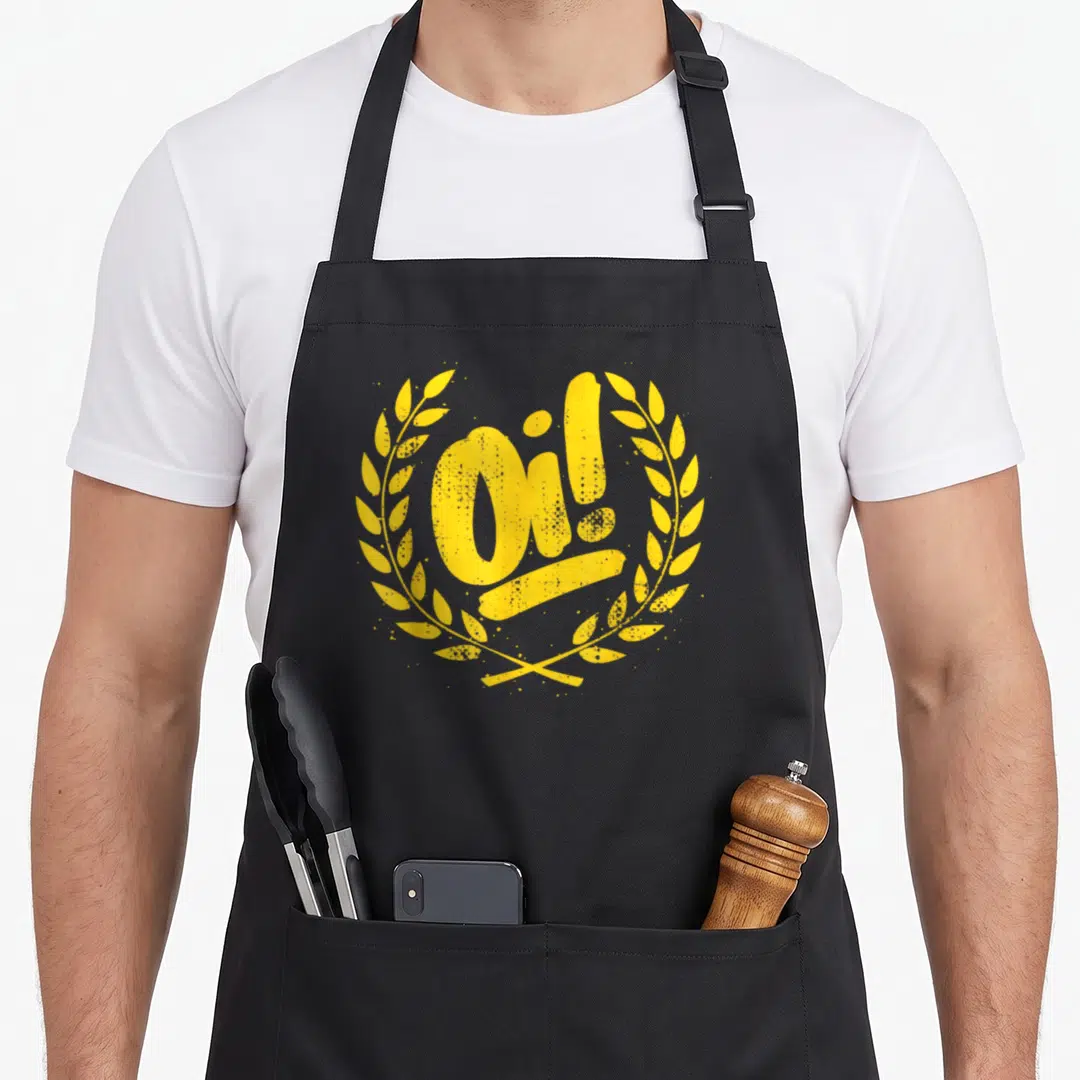 Ska punk rock apron - Distressed yellow Oi! text inside a circular laurel wreath — shown on a black cotton canvas apron against a white background