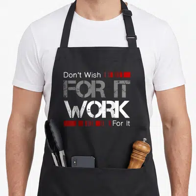 Wish uab kidkis apron - White text Don't Wish WORK For It with red rectangular bars stacked vertically — shown on a black cotton canvas apron against a white background