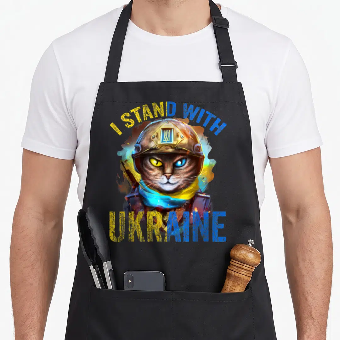 Pray cat apron - Realistic cat soldier with yellow and blue I STAND WITH UKRAINE text — shown on a black cotton canvas apron against a white background