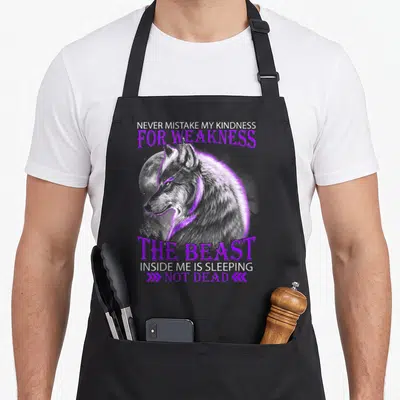 Mistake wolf apron - Realistic wolf head on moon with purple text NEVER MISTAKE MY KINDNESS FOR WEAKNESS — shown on a black cotton canvas apron against a white background