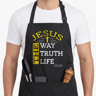 Biblical bible verse apron - JESUS THE WAY TRUTH LIFE typography with yellow cross and vertical box on black fabric — shown on a black cotton canvas apron against a white background