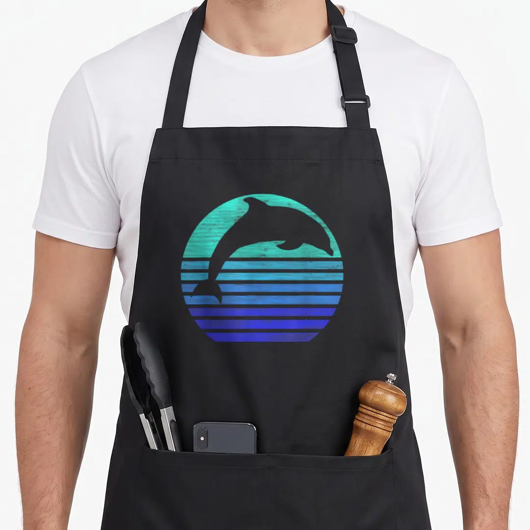 Dolphin animal retro apron - Grey dolphin silhouette in a teal and blue gradient circle with horizontal stripes — shown on a black cotton canvas apron against a white background
