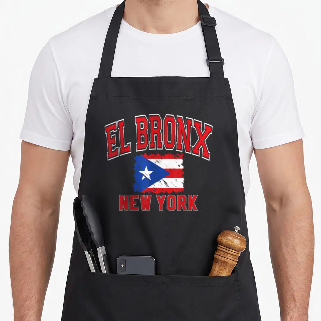 Paintbrush new york apron - El Bronx New York text surrounding a red white blue Puerto Rican flag graphic — shown on a black cotton canvas apron against a white background