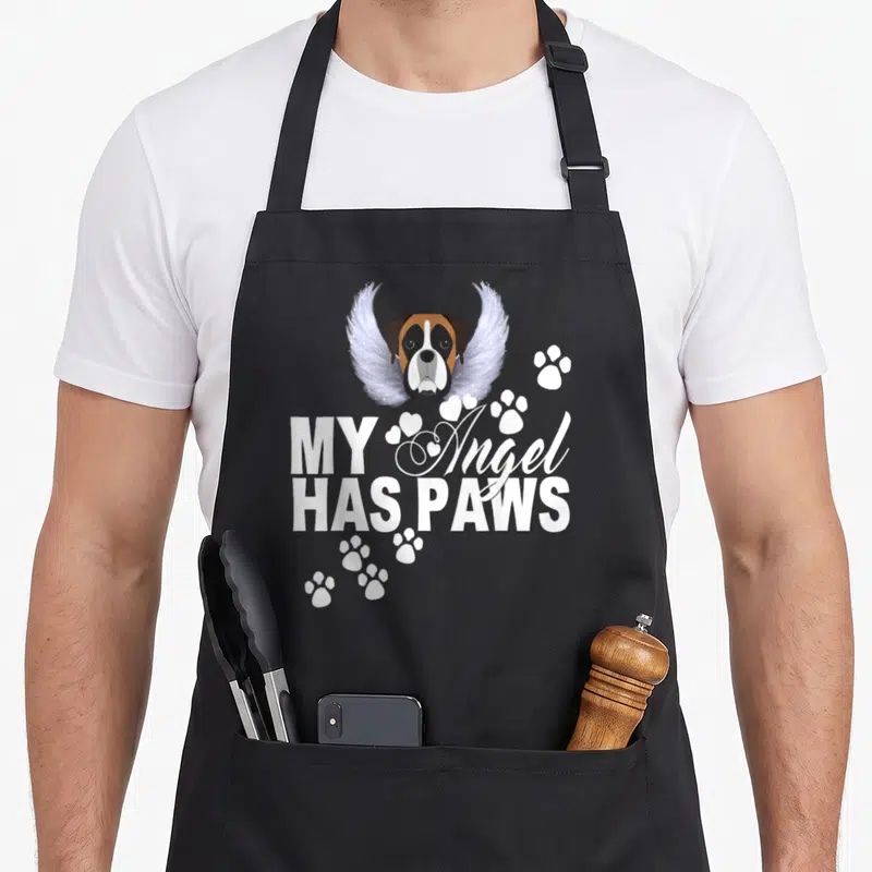 Angel boxer dog apron - Winged boxer head with MY Angel HAS PAWS text and paw prints — shown on a black cotton canvas apron against a white background
