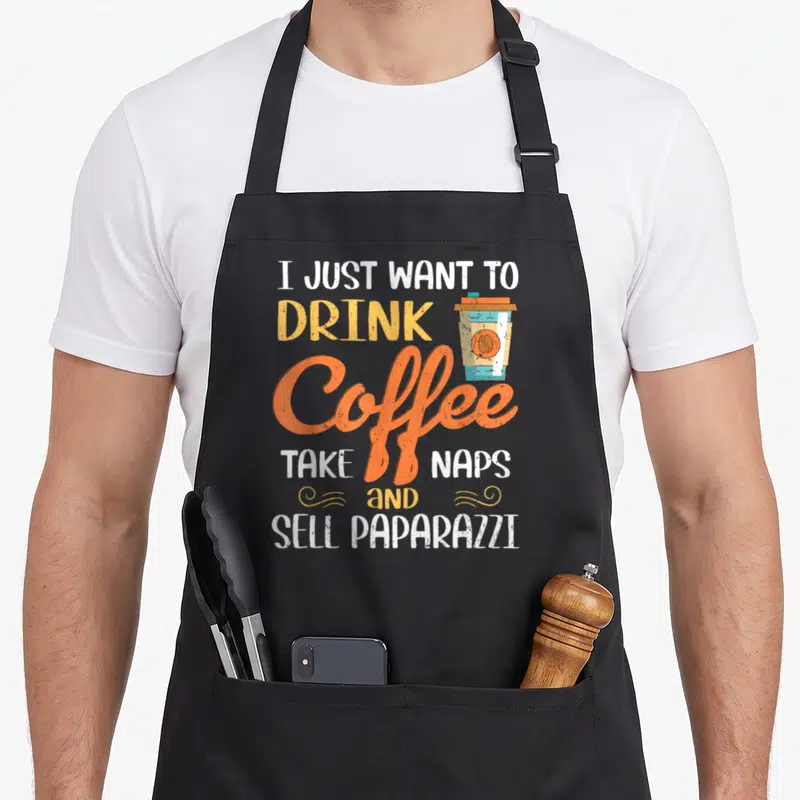 Paparazzi coffee apron - Stacked text I just want to drink coffee take naps and sell paparazzi with cup graphic — shown on a black cotton canvas apron against a white background