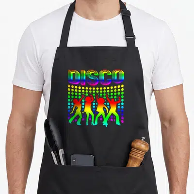 Themed dancing 70s apron - Rainbow DISCO text above colored dots and four dancing silhouettes — shown on a black cotton canvas apron against a white background