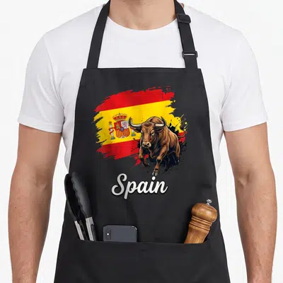 National spanish aprons - Realistic brown bull on red yellow brush stroke flag with white Spain script text — shown on a black cotton canvas apron against a white background