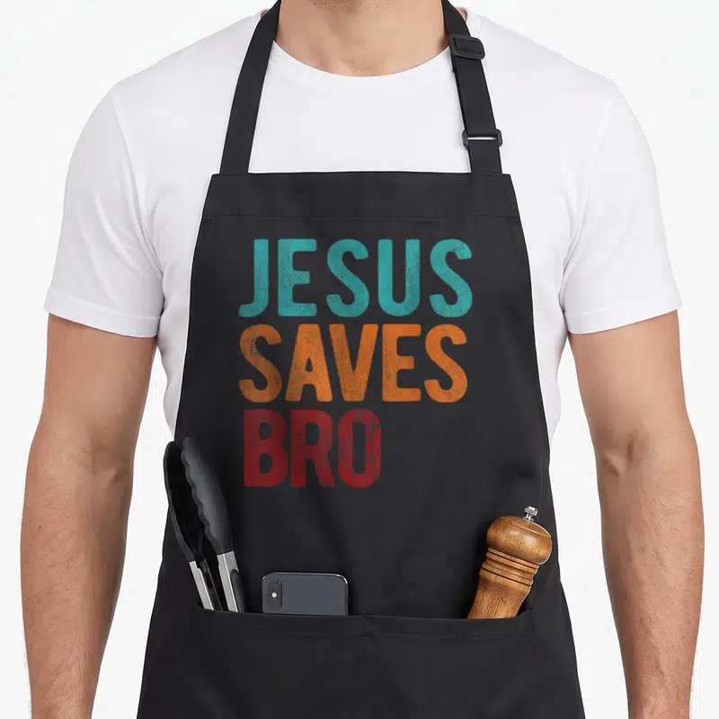 Save bro christian apron - JESUS SAVES BRO text in teal orange and red distressed block letters — shown on a black cotton canvas apron against a white background