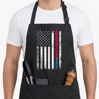 Sober us aprons - Distressed USA flag with vertical red SOBER and blue AF text separated by a white star — shown on a black cotton canvas apron against a white background