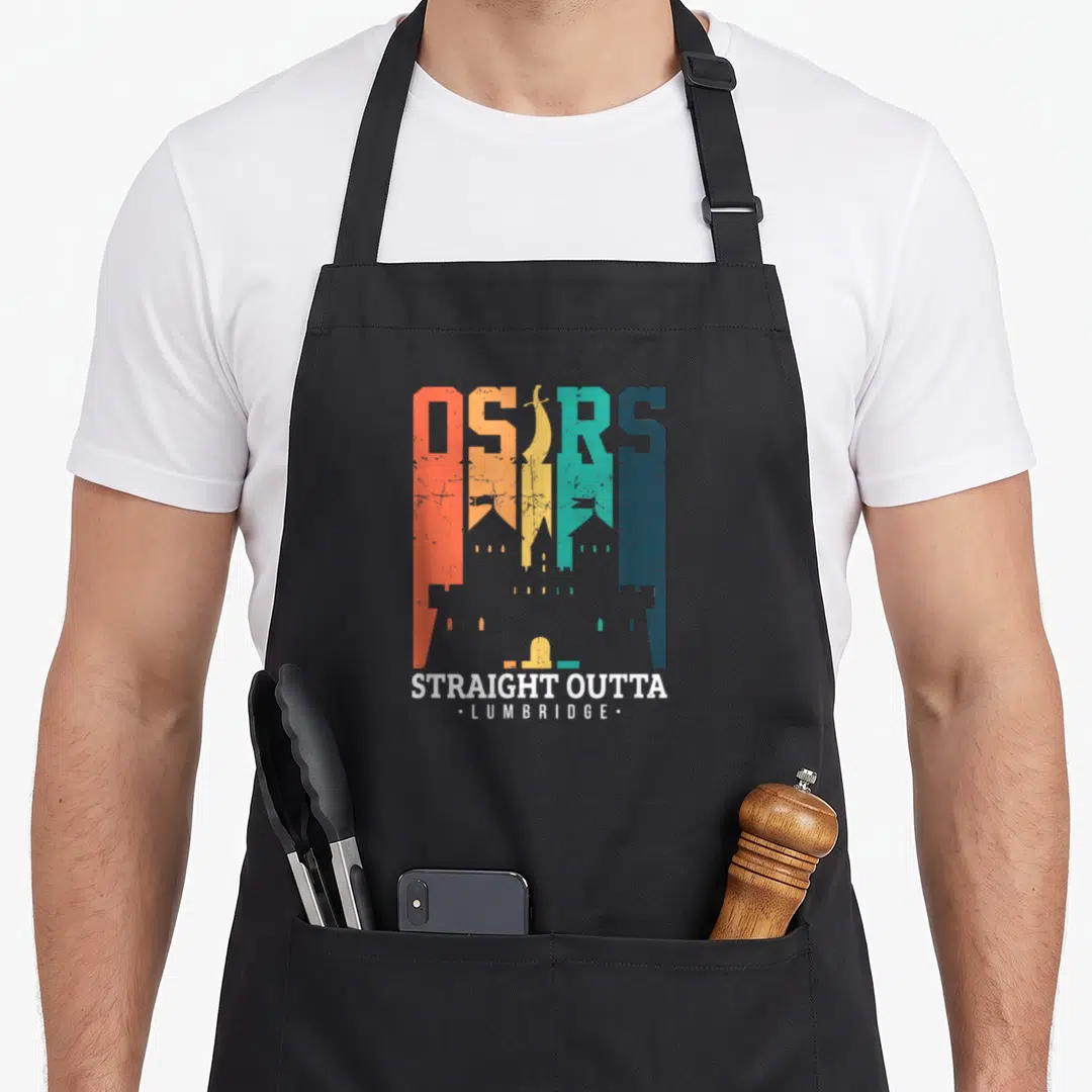 Commerce e.a apron - Multi-colored OSRS text with castle silhouette and Straight Outta Lumbridge caption — shown on a black cotton canvas apron against a white background