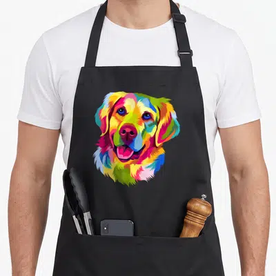 Pop golden retriever apron - Multicolored pop art golden retriever head in yellow blue red green pink — shown on a black cotton canvas apron against a white background