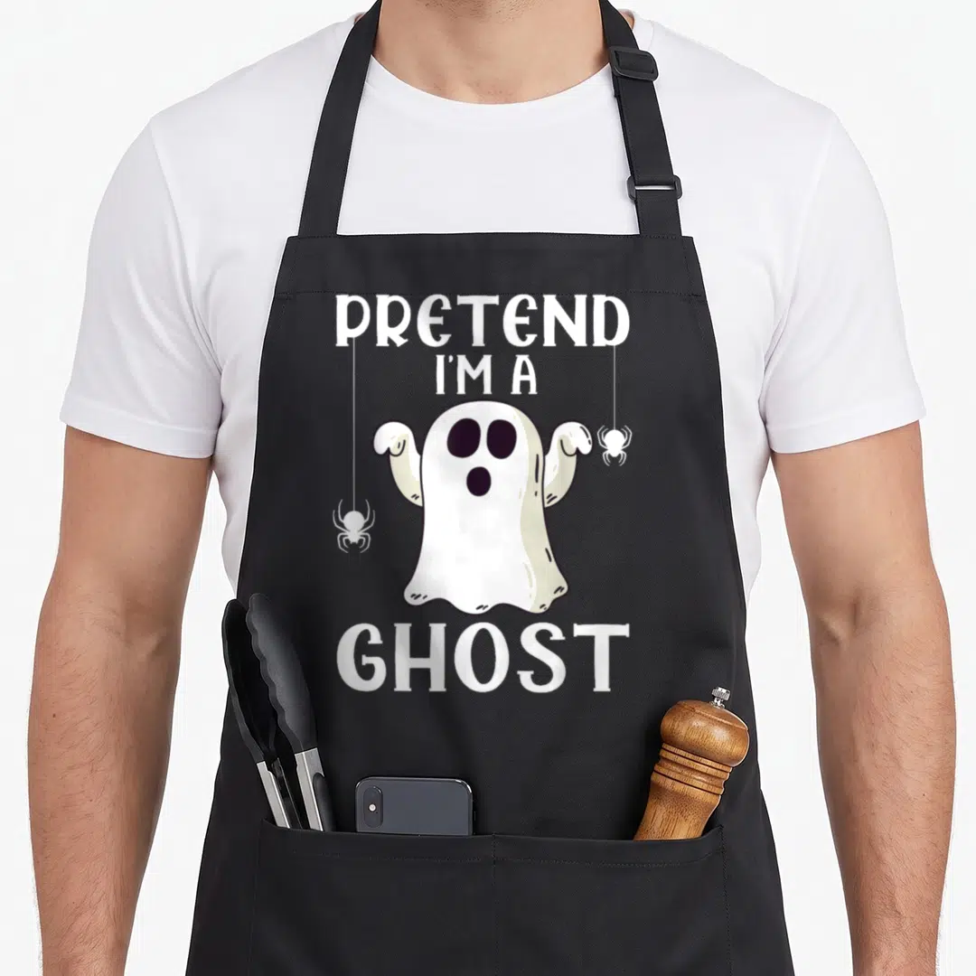 Pretend ghost halloween apron - Cartoon white ghost with two black spiders and text Pretend I'm A Ghost — shown on a black cotton canvas apron against a white background