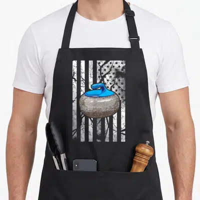 Player winter apron - Realistic curling stone with blue handle over distressed white and grey USA flag stripes — shown on a black cotton canvas apron against a white background