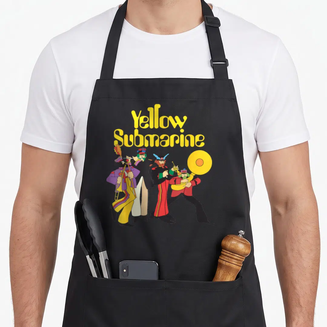 Funny yellow submarine apron - Stacked Yellow Submarine text above four cartoon musicians in colorful uniforms standing — shown on a black cotton canvas apron against a white background