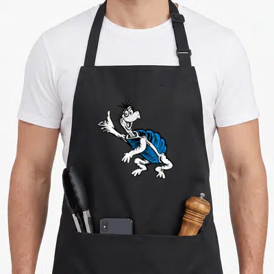Yertle turtle apron - Cartoon turtle with blue shell and white body extending one arm forward — shown on a black cotton canvas apron against a white background