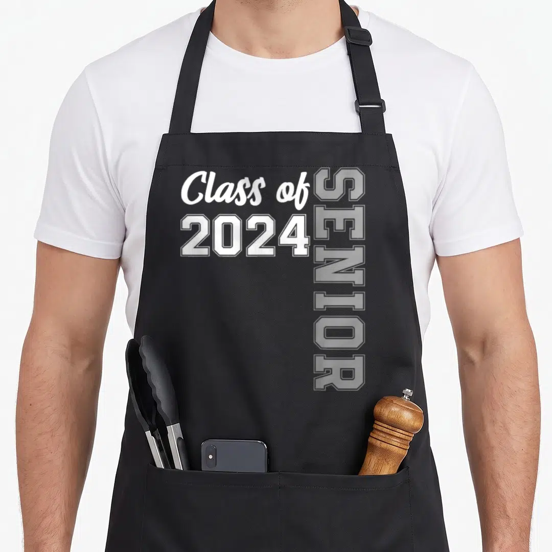 Class diploma apron - White Class of 2024 and vertical SENIOR text on grey background — shown on a black cotton canvas apron against a white background