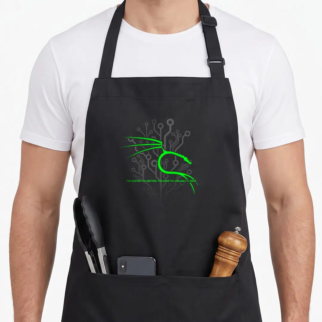 Backtrack dragon apron - Green stylized cat head over grey circuit lines with slogan text below — shown on a black cotton canvas apron against a white background