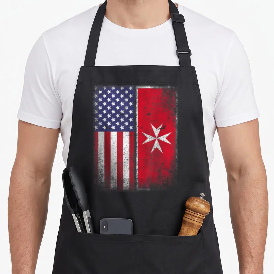 Maltese american flag apron - Two distressed flags, USA and Malta, printed in red white and blue — shown on a black cotton canvas apron against a white background
