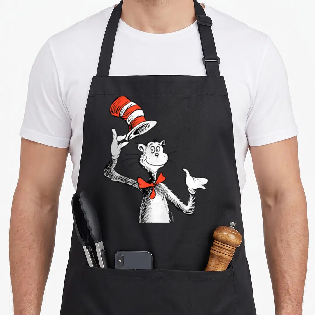 Funny hat cat apron - Cartoon cat tipping red and white striped hat with red bow tie — shown on a black cotton canvas apron against a white background