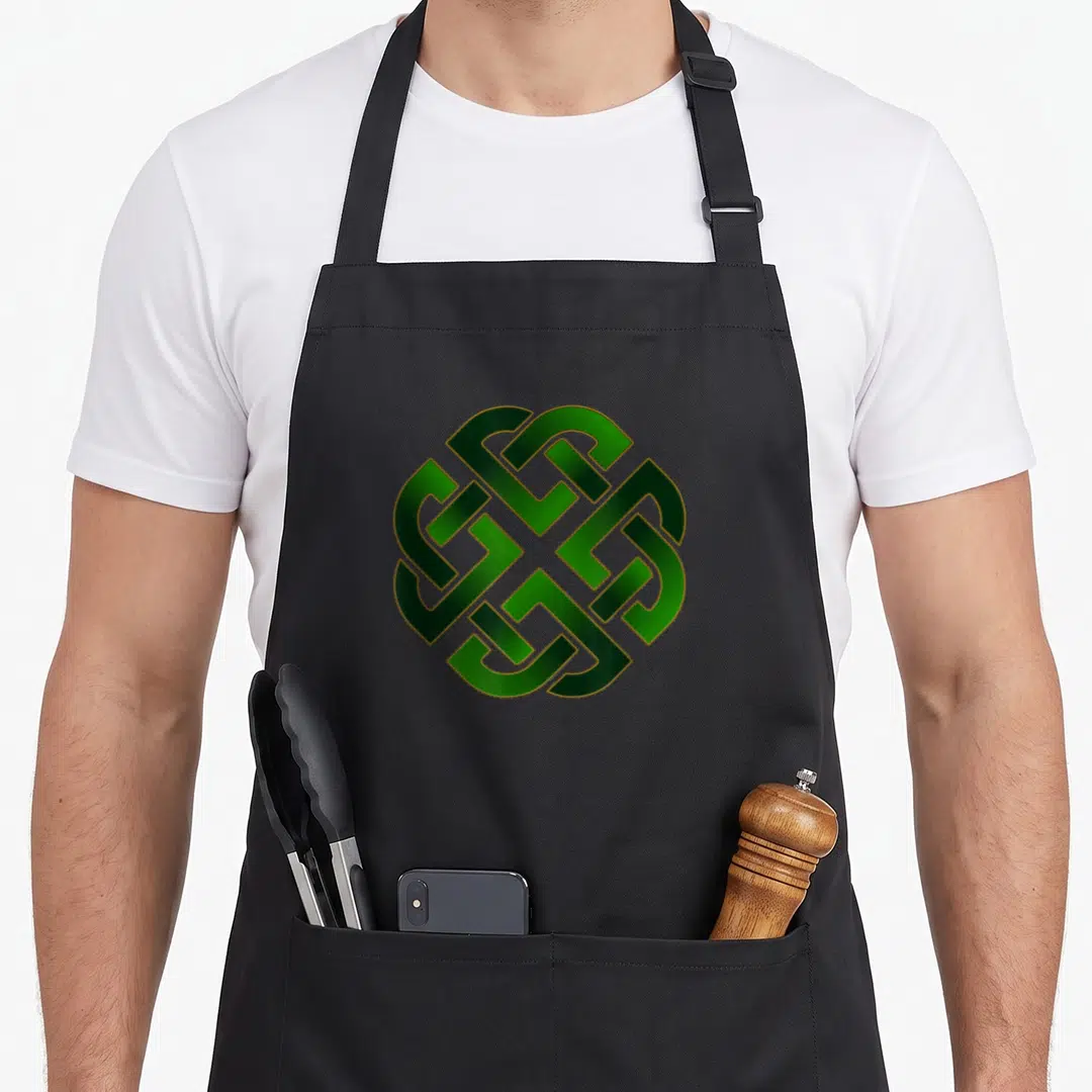 Emerald st patrick day aprons - Green and gold symmetrical Celtic knot pattern centered on apron front — shown on a black cotton canvas apron against a white background