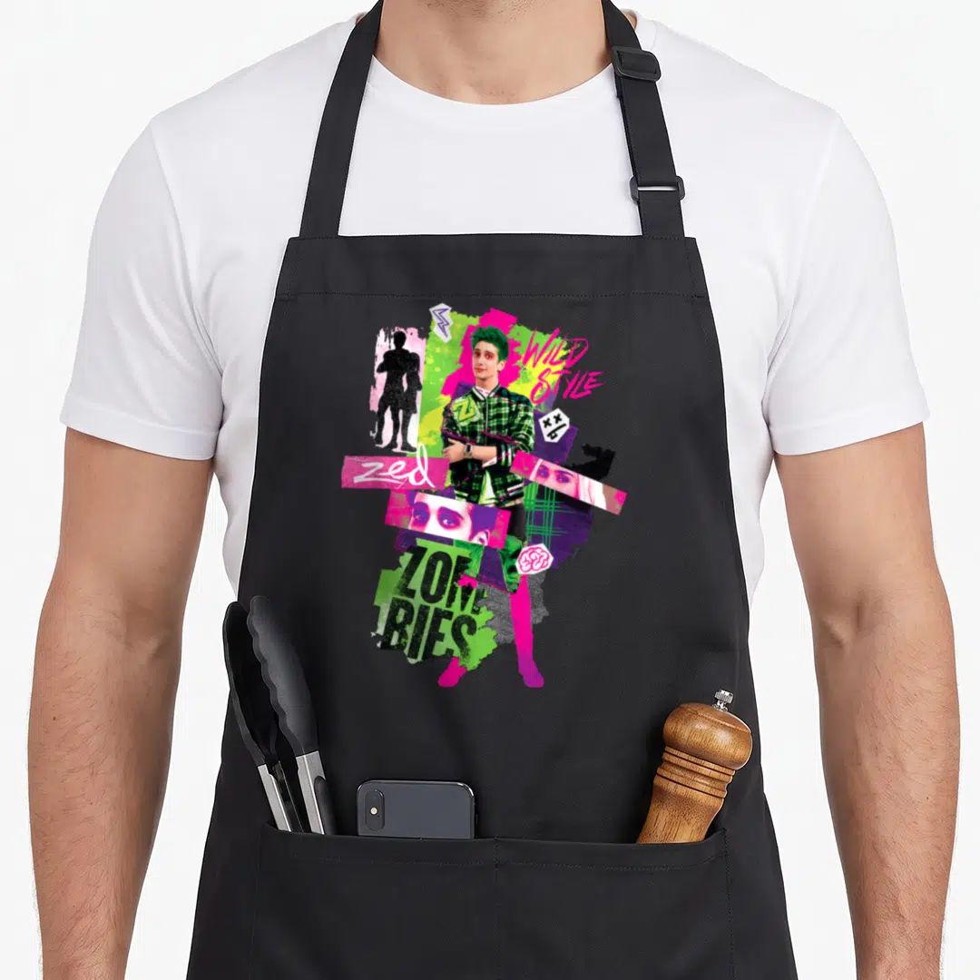 Channel m&s apron - Zed in plaid jacket with WILD STYLE text, brain icon, and collage elements in green pink black white — shown on a black cotton canvas apron against a white background