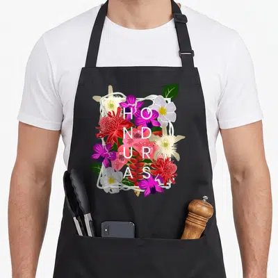 Honduras pride apron - Vertical HONDURAS text overlaid on purple and red tropical flowers inside a white frame — shown on a black cotton canvas apron against a white background